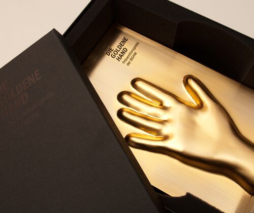 Die Trophy der GOLDENEN HAND in einer dunkelgrauen Schachtel