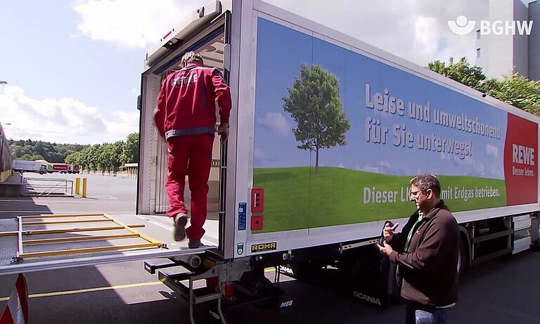 Mitarbeiter von Rewe beim besteigen der Laderampt eines LKWs mit Hilfe eines aufklappbaren Aufstiegs