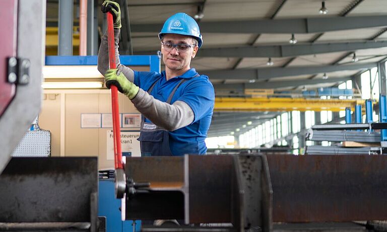 Ein Mechaniker der Firma Thyssendrupp Schulte arbeitet in einer Metallwerkstatt mit einem rückschlagfreien Träger-Wendeeisen