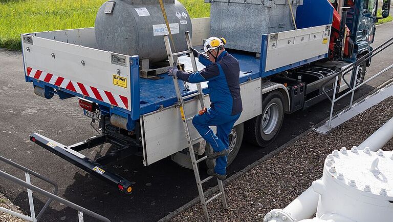 Mitarbeiter von NWO steigt die gesicherte Leiter hoch auf einen LKW