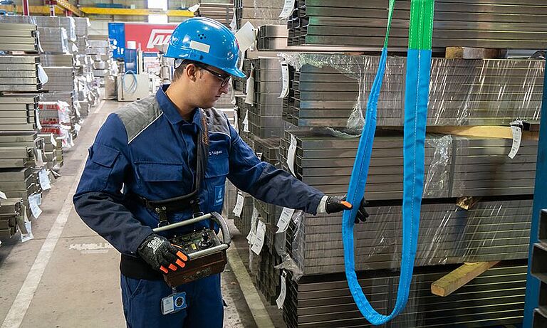 Ein Mitarbeiter der Firma Thyssenkrupp Inspiziert in einer Lagerhalle eine große Schlaufe