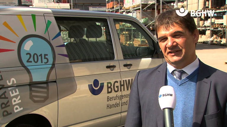 BayWa Sicherheitsexperte Herbert Wolf wird vor einem Fahrzeug der BGHW Interviewt