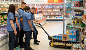 Mitarbeiter*innen eines Supermarktes beim Einräumen von Produkten